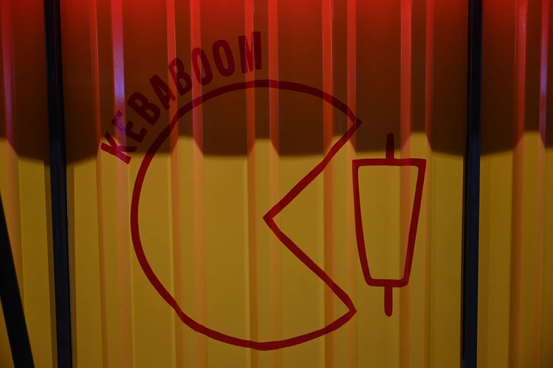 Kebaboomi logo kollasel ja punasel seinal